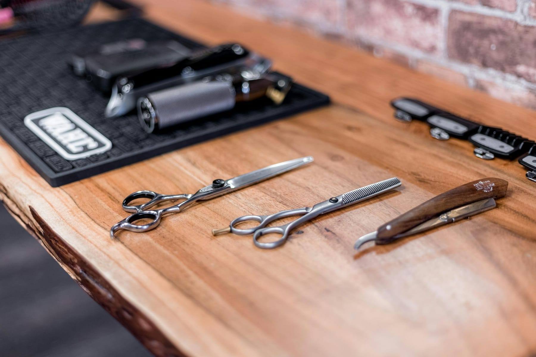 Shears and razors laid out on a wooden bench