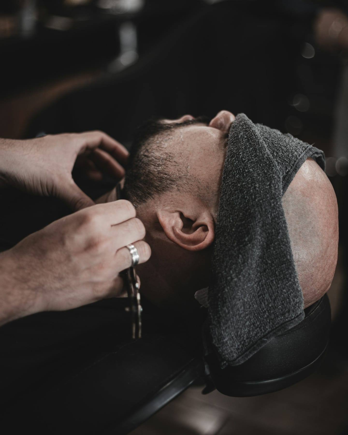 Beard trim with a towel draped over the client
